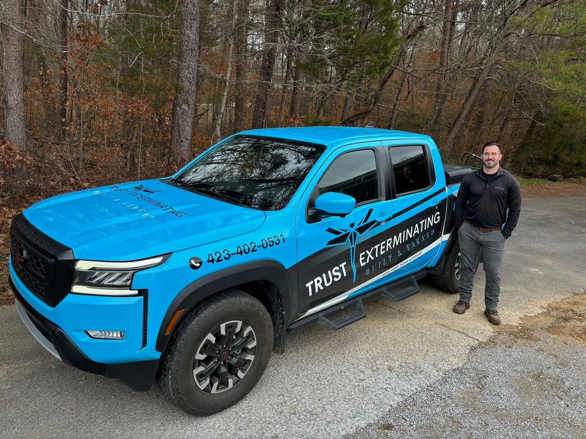 Jerry Weaver standing beside a Trust Exterminating truck